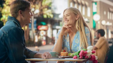 Genç ve güzel bir çift bir kafede romantik bir randevu yaşıyor. Mutlu Adam ve Kadın Terasta Oturuyor ve Keyifli Konuşmalar Yapıyorlar