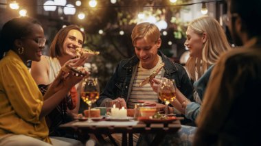 Genç Çok Irklı Dostlar Bir Kafede Gecenin Tadını Çıkarıyorlar. Lezzetli İtalyan pizzası yiyorum. Terasta Eğlenen Genç Erkekler ve Kadınlar