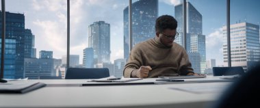 Ofiste Masa başında oturan, Dizüstü bilgisayar kullanan, Gökdelenler Gören Büyük Şehir 'li Büyük Pencere' nin yanında oturan kendine güvenen bir iş adamı. Satış Yöneticisi