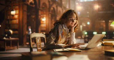 Çevrimiçi Eğitimde Çevrimiçi Genç Kadın Klasik Kütüphanede Dizüstü bilgisayar kullanıyor. Kıvırcık Saçlı Kolej Araştırmaları Antik Çağ 'da