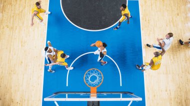 Yetenekli bir basketbolcunun Sayı Turu Sayı Turuna Sıçrayan Top Down Manzarası. Basketbol maçında oynayan iki uluslararası takımın çekimi.