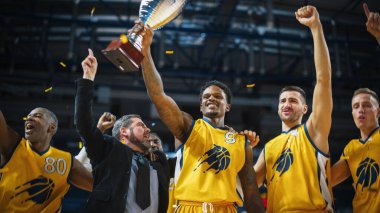 Çok ırklı basketbol oyuncuları şampiyonluğu kucaklaşarak, zıplayarak ve kupayı tutarak kutluyor. Özel Neşeli Spor Aksiyonu Canlı yayında ve