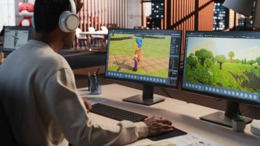 Hint erkek oyun tasarımcısı 3 boyutlu modelleme yazılımlı masaüstü bilgisayarı kullanarak karakterler tasarlıyor ve oyun için dünya düzenliyor. Erkek