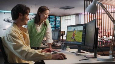 3 boyutlu modelleme yazılımı ile Masaüstü Bilgisayar kullanan ve Oyun Tasarım Stüdyosunda Asyalı Kadın Proje Yöneticisi ile konuşan Kafkas Erkek Oyun Geliştiricisi