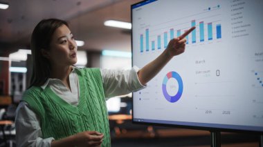 Yaratıcı Ofis Toplantısı: Pazarlama Stratejisi için Finansal Hedefleri Sunan Güzel Asya Kadın Proje Yöneticisinin Portresi, Veri ile TV Kullanımı