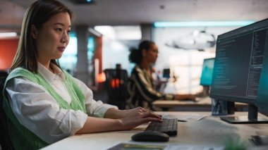 Oyun Geliştirme Stüdyosundaki Kadın Asya Oyun Programı Bilgisayar Kodlaması. Odaklanmış Kadın Kod Satırları Yazıyor, Yapay Zeka