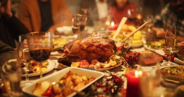 Lezzetli dekore edilmiş Noel ziyafeti masası ızgara hindi tabağı, sebze ve meyve yemekleri, fırında patates, tatlı ve içeceklerle