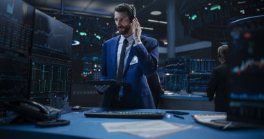 Bir tablet bilgisayarda çalışan, hisse senedi verilerini araştıran, emtiaları ve borsayı analiz eden yakışıklı bir borsa simsarının portresi