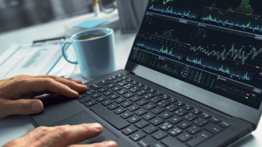 Profesyonel Finansal Analistin Ellerine Kapan Dizüstü bilgisayarını kullanarak Menkul Kıymetler ve Çizelgeler Ekranında. Borsayı Analiz Eden Adam