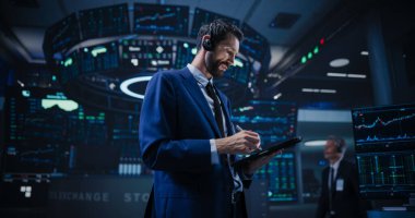 Low Angle Portrait of an Energetic Stock Exchange Manager Working in Modern Office. Proactive Trader Communicating Orders with a Headset and clipart