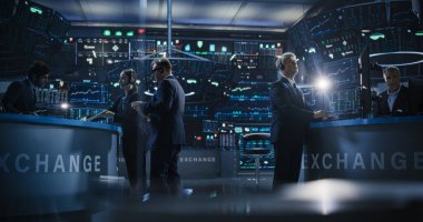 Gerçek zamanlı borsa ve borsa grafikleri olan birden fazla bilgisayar ekranı olan bir ofiste çalışan borsa simsarları. İş Adamları