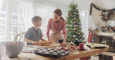 Anne ve Oğlu 'nun Noel' de zencefilli çörek pişirme portresi. Küçük şirin çocuk annesine ev işlerinde ve aşçılıkta yardım ediyor.