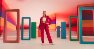 Parlak Aydınlık Oda 'da kendine güvenen bir kadının düşük açılı portresi. Renkli Yaratıcı Stüdyoda Poz Veren Moda Genç Kadın