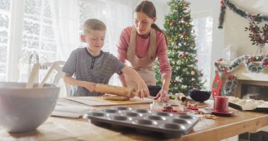 Anne ve Oğlu 'nun Noel' de zencefilli çörek pişirme portresi. Küçük şirin çocuk annesine ev işlerinde ve aşçılıkta yardım ediyor.