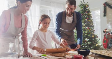 Tatilleri Kutlayan Aile: Ebeveynler ve Çocuk Noel 'de Birlikte Yemek Yapıyor. Tatlı küçük kız ve ailesi zencefilli kurabiye yapıyor. Mutlu