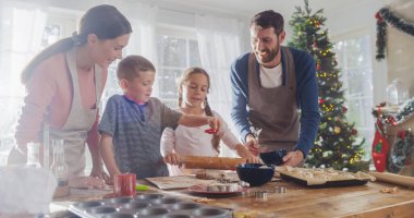 Sevimli çocukların portresi Noel 'de ailelerinin evde pişirmesine yardım ediyor. Aile Eğleniyor, İşbirliği yapıyor, Tatilde Hamur ve Kurabiye Yapıyor