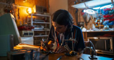 90 'lardaki eski masaüstü bilgisayarının önünde lehim aleti kullanan beyaz erkek mühendisin portresi. Mühendislik Öğrencisi