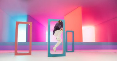 Genç ve Atletik Kafkasyalı B-Boy Soyut Neon Lit Stüdyosunda Yenilmek İçin Dans Ediyor. Enerjik Moda Erkek Dansçısı Yetenekli