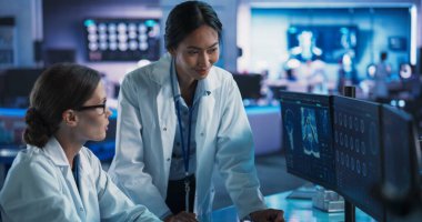 Tıbbi Araştırma Merkezi: Kafkas ve Asyalı kadın bilim adamları insan beyninin MRI taramalarıyla konuşan ve kullanan masaüstü bilgisayarları. Cerrah