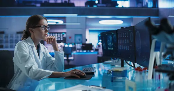 stock image Hospital Research Laboratory: Female Medical Scientist Using Computer with Brain Scan MRI Images. Professional Neurologist Analysing CT Scan, Finding