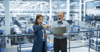 Deneyimli Orta Çağ Mühendisi Genç Japon Öğrenciye Elektronik Fabrikası Turu düzenliyor. Teknik Geçmişi Olan Asyalı Kadın Sorular Soruyor