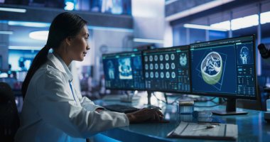 Modern Tıp Araştırma Merkezi Laboratuvarında insan beyni tomografisi ile Masaüstü Bilgisayarı kullanan Asyalı Kadın Nörobilimci. Profesyonel Doktor Arıyor