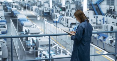 Otomatik Robot Elleri 'yle çalışan bir Modern Elektronik Fabrikası' nda düşünceli Asyalı Mühendis İzleme ve Analiz Koşulları