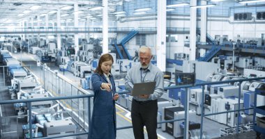 Orta Çağ Mühendisi ve Genç Japon Teknisyen Laptop Bilgisayar kullanıyor. Şartları İzleyen, Analiz eden Uzmanlar