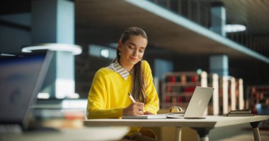Çekici Çok Irklı Öğrenci Laptop Bilgisayarına Sosyal Bilimler Kompozisyonu Yazıyor ve Not Defterine Not Alıyor. Genç Şık Kadın Çalışması