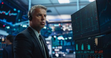 Çağrının diğer tarafındaki operatöre canlı açık arttırma, haberleşme ve satış emirlerini takip eden yakışıklı orta yaşlı borsa simsarı.