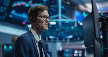 Ciddi Odaklı İfadeyle Profesyonel Borsa İşlemcisi. Borsacı bir telefon üzerine müşterilerle konuşuyor.