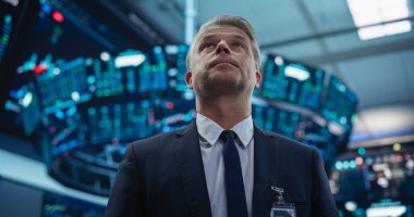 Yakışıklı bir Yetişkin Borsacı Portresi Salonda Çalışıyor, Gerçek Zamanlı Borsa Verilerini İzliyor, Ürünleri ve Borsayı Analiz Ediyor