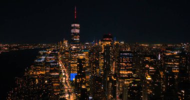 Tek Dünya Ticaret Merkezi Gökdelenli Gece Havası Fotoğrafı Ofis Odalarında Işıklar Var. Helikopter bir görünümü olan binaya yakın uçuyor.