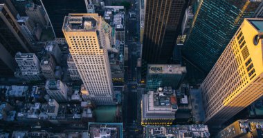 Manhattan 'daki New York caddelerinin tepeden aşağı hava manzarası, iş ve konut binalarının çatıları. Helikopter Arabalarla Düz Yol 'da Uçuyor