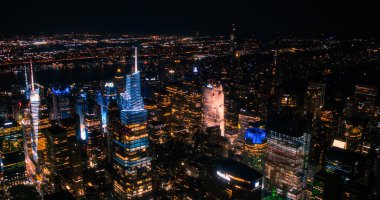 Gece vakti New York Şehir Mimarisi Helikopter Turu. Midtown Manhattan Ofis Binaları ve Madison Square Garden 'a doğru gökdelenler. Hava Kentsel
