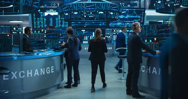 Gerçek zamanlı borsa ve borsa grafikleri olan birden fazla bilgisayar ekranı olan bir ofiste çalışan borsa simsarları. Yöneticiler