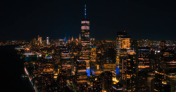 Night Aerial Photo with the One World Trade Center Skyscraper with Lights in Office Rooms Inside. Helicopter Flying Close to the Building with a View