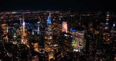 Gece vakti New York Şehir Mimarisi Helikopter Turu. Manhattan şehir merkezindeki ofis binaları ve gökdelenler üzerinden Madison Square Garden 'a doğru uçuyor.