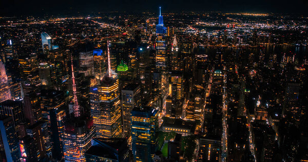 New York City Aerial Skyline with Historic and Modern Manhattan Skyscrapers and Residential Buildings at Night. Scenic Helicopter View of Popular