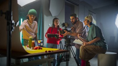Çeşitli Genç Film Yapımcıları, Yaratıcılık ve Ekip Çalışmalarını Yansıtırken Canlı Bir Sete İşbirliği Yapıyor, Sahne Detaylarını Konuşurken Kamera Ayarlarına Odaklanıyor