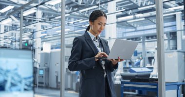 Asya Fabrikası Yöneticisi Futuristic Industrial Manufacture 'da Otonom Robotik Kurulum Hattı ile Laptop üzerinde çalışıyor. Uzman İzleme Üretimi