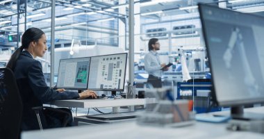 Ofisteki bir bilgisayar üzerinde yaratıcı işler yapan Asyalı Endüstriyel Mühendis. Güçlü mikroçiplerle Yenilikçi Bir Ana Kart Oluşturan Zeki Kadın