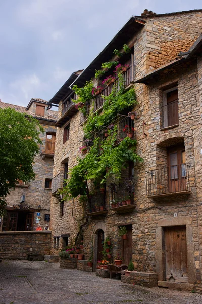 バルコニーに花と石造りの家のファサード 北スペインの町の典型的な建築 — ストック写真