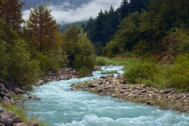 Dağ manzarası, şeffaf sulardan oluşan muazzam bir nehir.