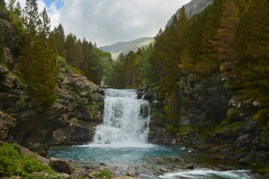 Renkli sonbaharda şelaleli dağ manzarası. Soaso, Ordesa y Monte Perdido Ulusal Parkı, İspanyol Pireneleri 'ne adım attı.