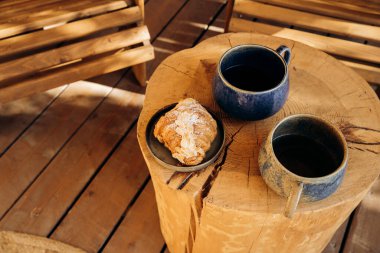 Sabah kahvaltısı, çay ve kruvasan ahşap bir masada. Kamp için yemek, yemek servisi, yemek servisi. Günlük tablosu
