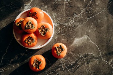 Mermer tezgahta taze hurmalar var. Sağlıklı yeme kavramı