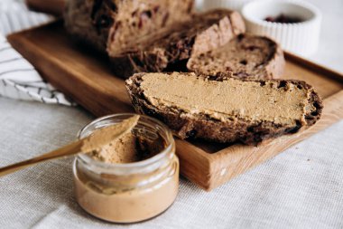 Ahşap bir tahtanın üzerinde yaban mersini ve kuru üzümlü ev yapımı ezme ve ekmek. Masa ayarı, kafe, restoran, menü