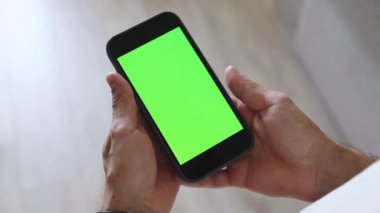 Bir adam elinde yeşil ekranlı bir telefon tutuyor. Telefon ekranınızda kromakey kullanıyorsunuz. Mesaj için yer, resimler. İş, finans, eğitim.