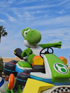 Osaka, Japonya - 11 Aralık 2023: Yoshi, Japonya Universal Stüdyoları 'ndaki geçit töreninde kartından gelen ziyaretçileri karşıladı..